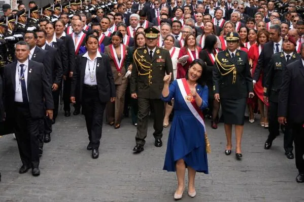 Keiko Fujimori, con la banda presidencial, camina rodeada de congresistas y escolta militar tras su toma de mando.